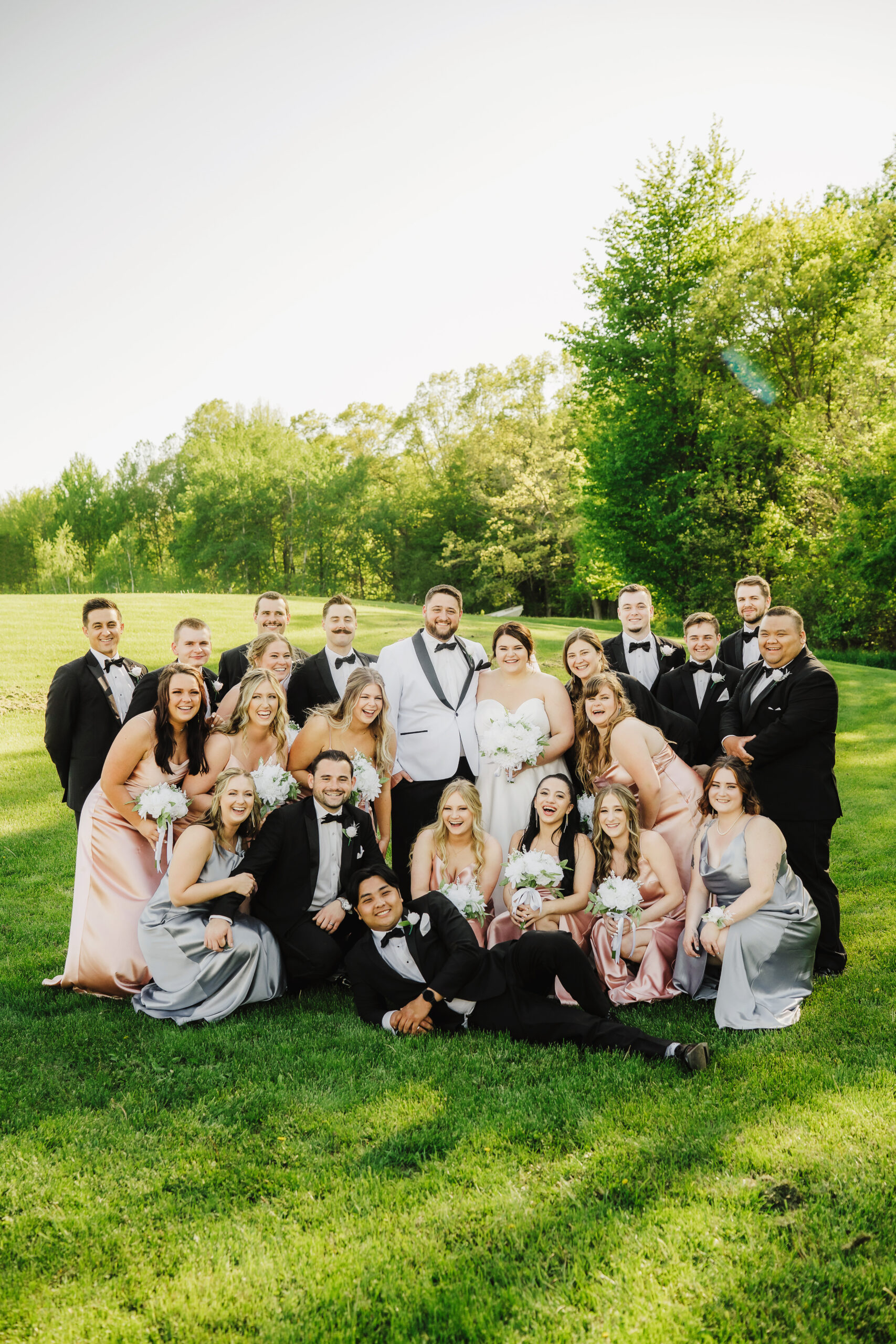 This bridal party group photo on the orchard lawn shows off all of their fun personalities. Bridal party photos Outdoor wedding Bridal party poses #dixonappleorchard #orchardweddingvenue #outdoorwedding #appleorchardwedding #wisconsinweddingvenue