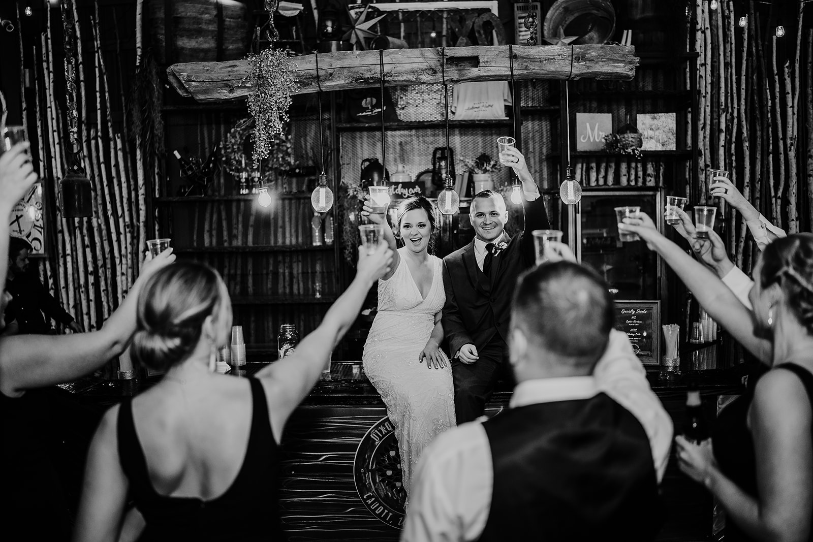 The Wisconsin newlyweds toast to their guests in their rustic wedding venue bar. Chippewa Valley wedding Rustic wedding day Black and white wedding photos #dixonappleorchard #orchardweddingvenue #outdoorwedding #appleorchardwedding #wisconsinweddingvenue