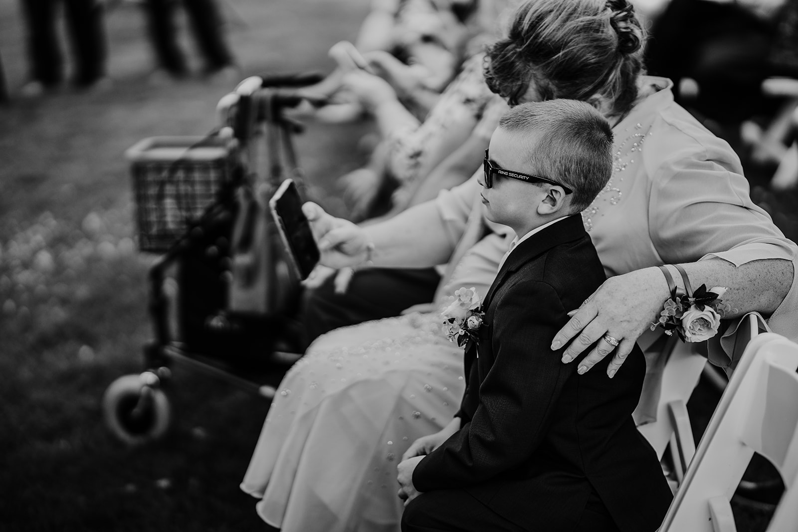Wedding guests look at the program as they wait for the Wisconsin wedding ceremony to begin. Black and white wedding photos Wedding guest photos #wisconsinweddingphotographer #choosingaphotographer #lakesidewedding #waterfrontweddingceremony
