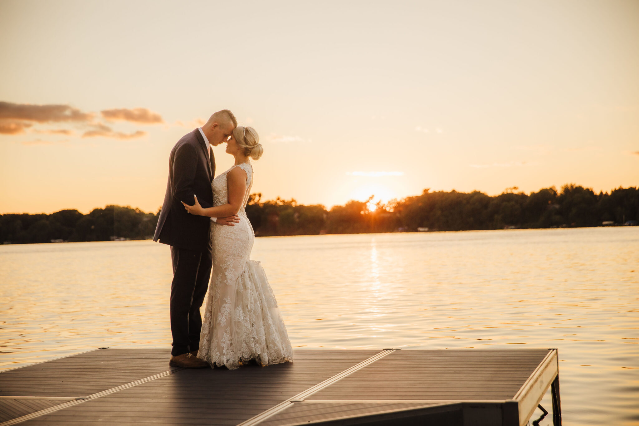 A stunning sunset wedding portrait of the bride and groom after their Wisconsin lakeside wedding ceremony. Sunset bridals Golden hour photography Wisconsin wedding photos #wisconsinweddingphotographer #choosingaphotographer #lakesidewedding #waterfrontweddingceremony