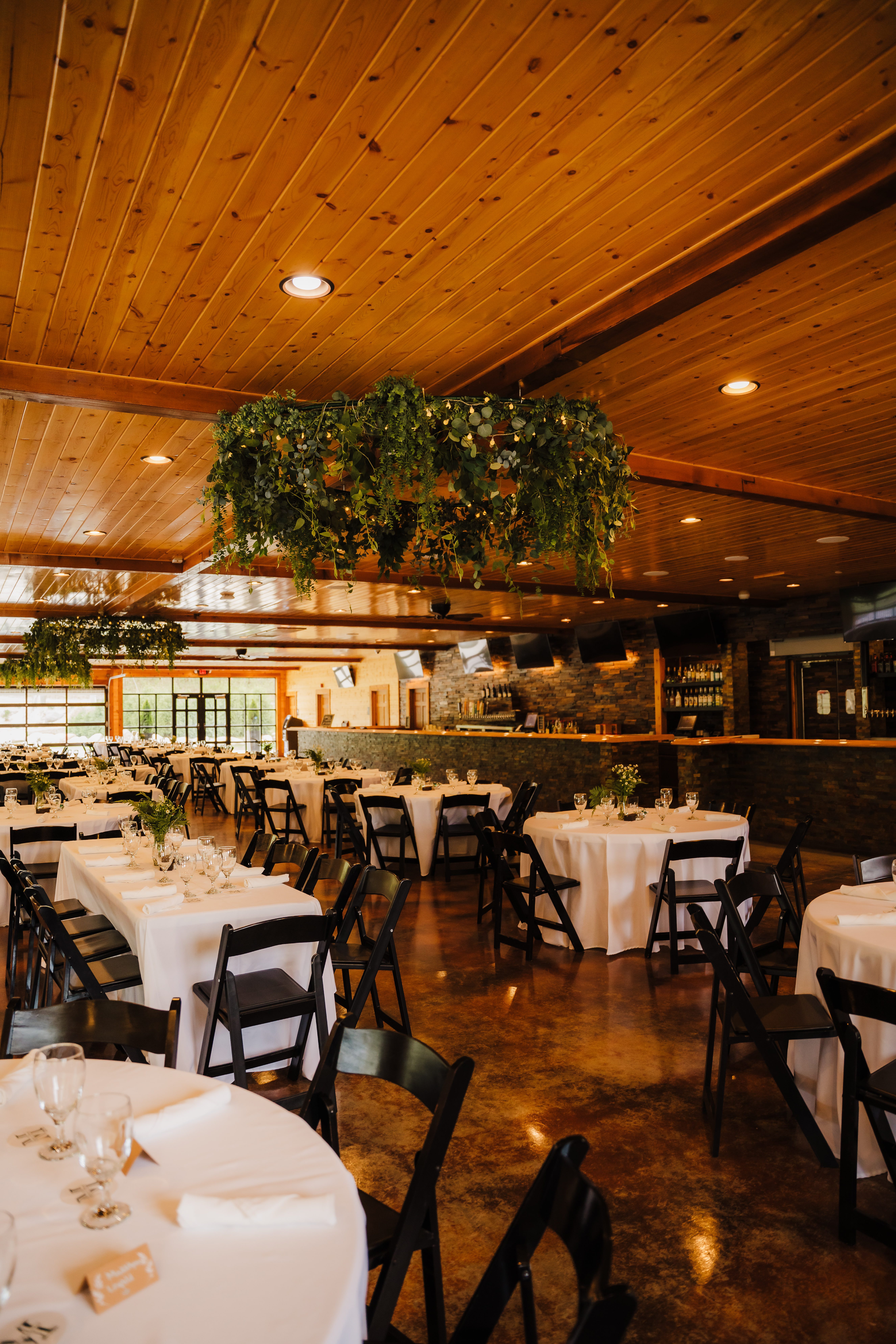 Beautiful greenery hangs from the ceilings at a rustic wedding venue in Wisconsin. Boho wedding decor Wedding reception greenery Forest wedding venue #forestgreenwedding #rusticweddingvenue #weddingplanning #wisconsinweddingphotographer #wisconsinweddingvenue