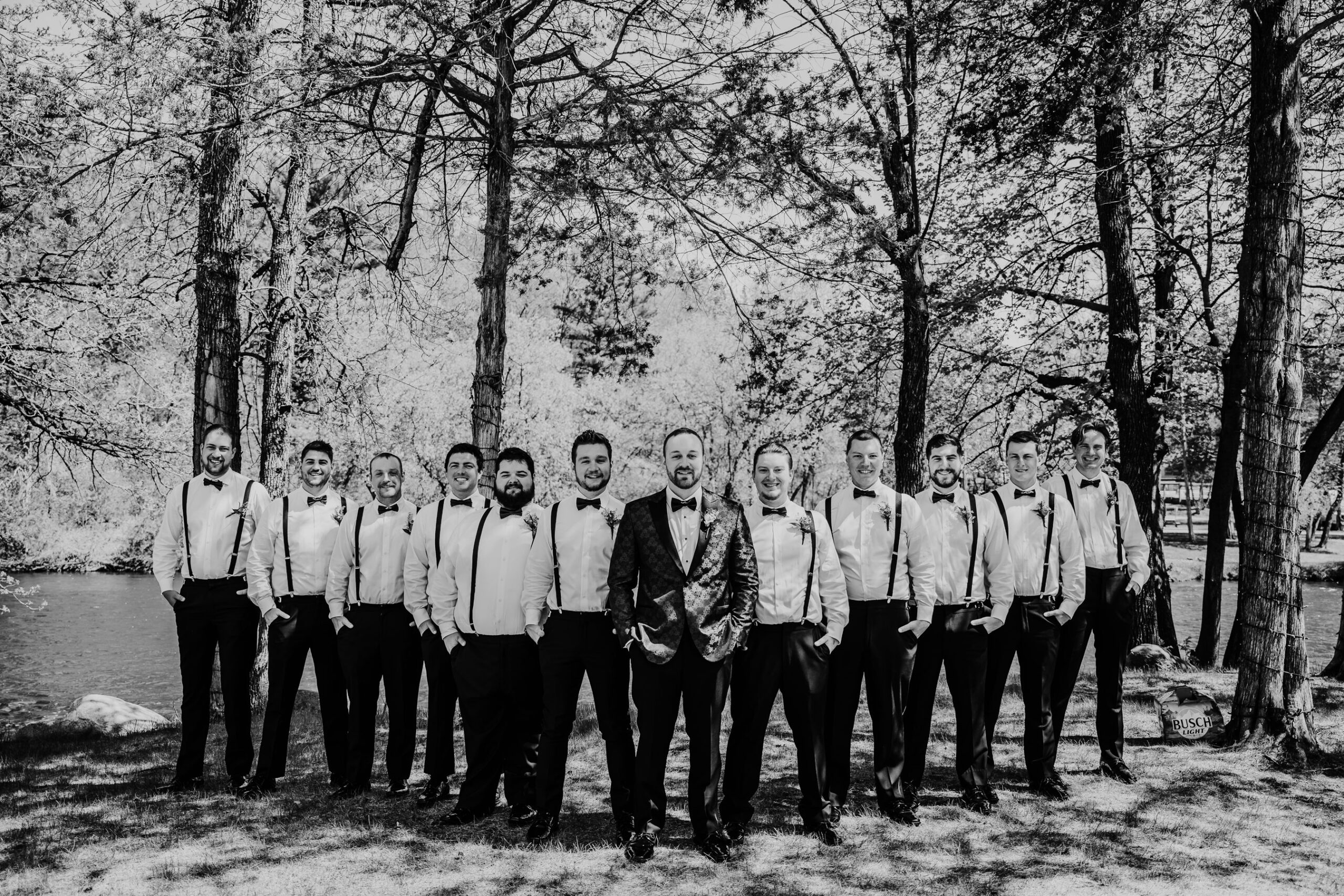 The groom and his Wisconsin groomsmen pose in their black suspenders and bowties. Groomsmen photos Bridal party portraits Groom outfit inspo #forestgreenwedding #rusticweddingvenue #weddingplanning #wisconsinweddingphotographer #wisconsinweddingvenue