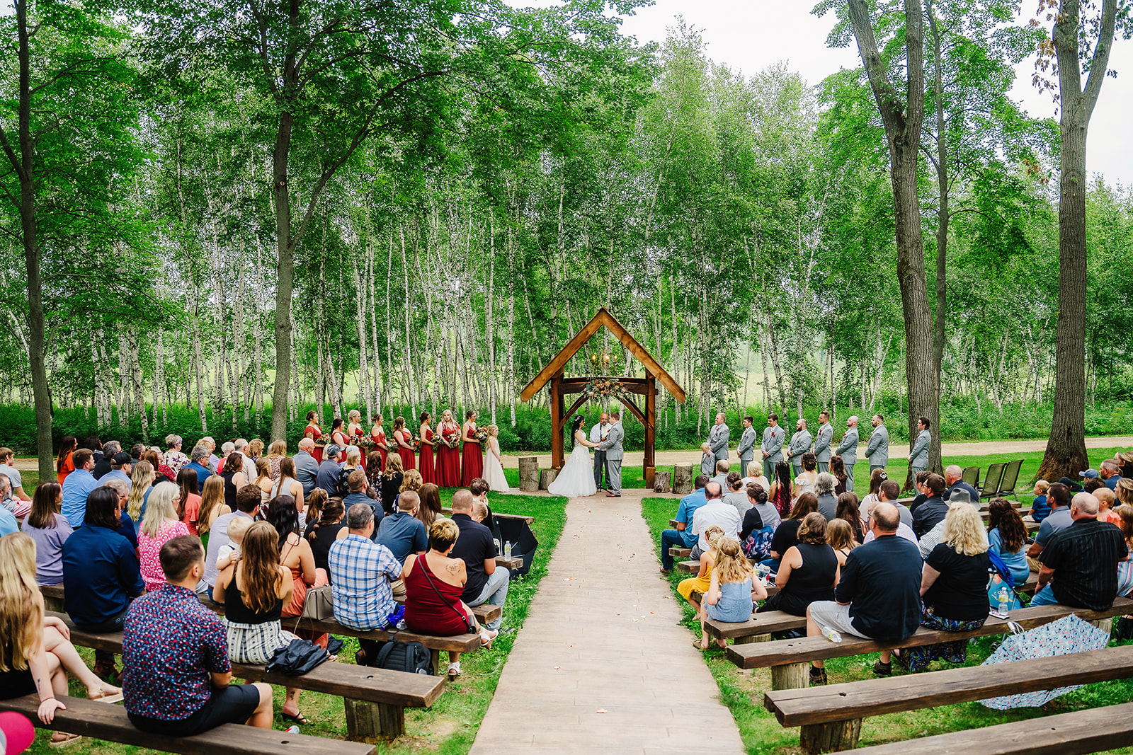 A gorgeous wedding ceremony takes place under a rustic arch at Dixon Apple Orchards. Outdoor wedding seating Rustic wedding ceremony Wisconsin wedding venue #dixonappleorchard #orchardweddingvenue #outdoorwedding #appleorchardwedding #wisconsinweddingvenue
