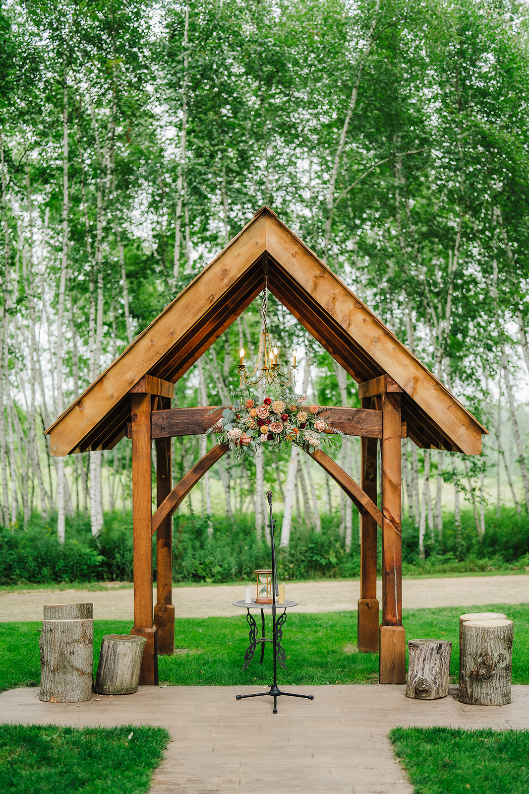 A rustic arch adorned with flowers is ready for the Chippewa Valley wedding ceremony to begin. Apple orchard venue Rustic wedding arch Rustic wedding ceremony #dixonappleorchard #orchardweddingvenue #outdoorwedding #appleorchardwedding #wisconsinweddingvenue

