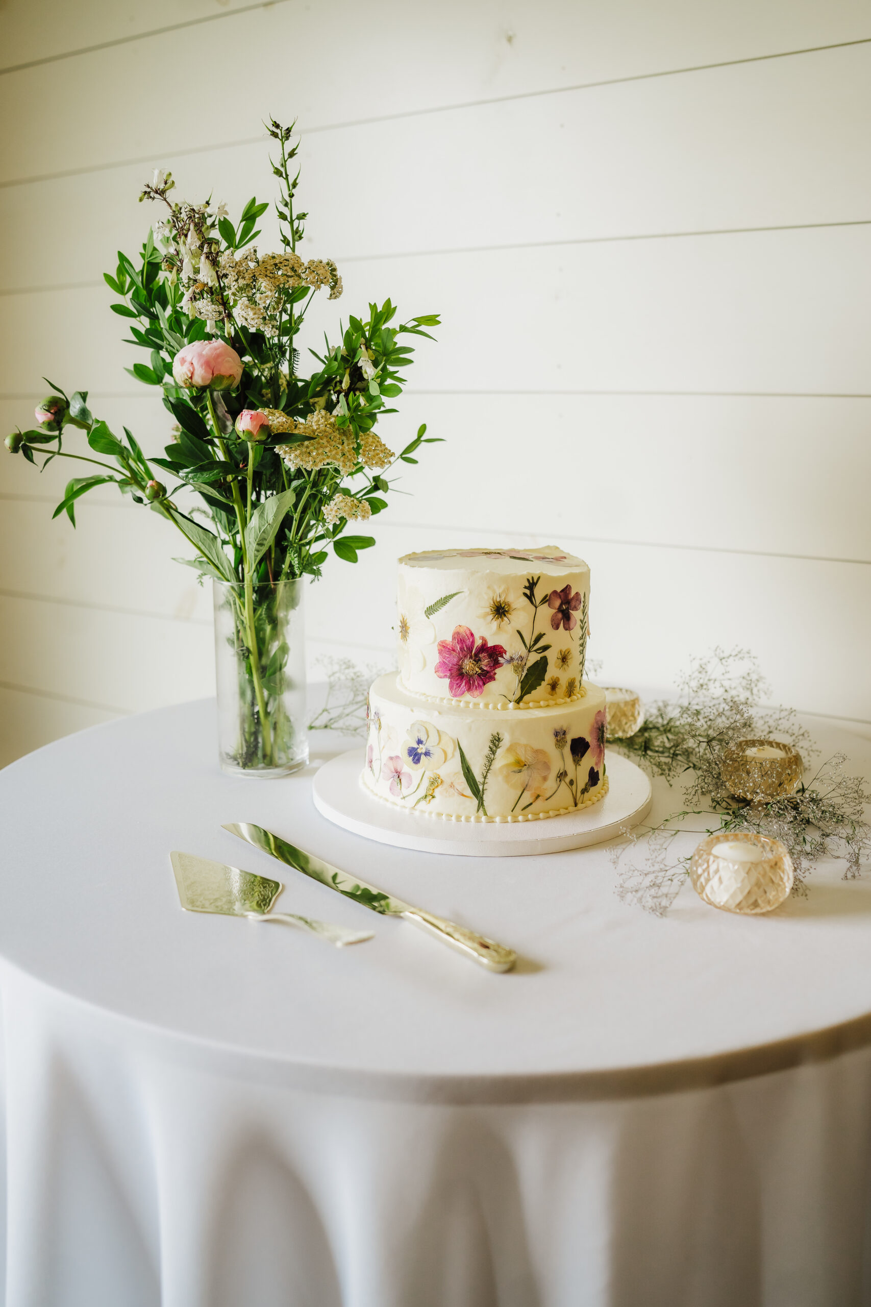 A beautiful floral wedding cake is frosted with colorful icing flowers on the reception cake table. Wedding cake inspo Floral wedding cake Small wedding cake#weddinginspiration #weddingplanning #diywedding #wisconsinweddingphotographer #armywedding
