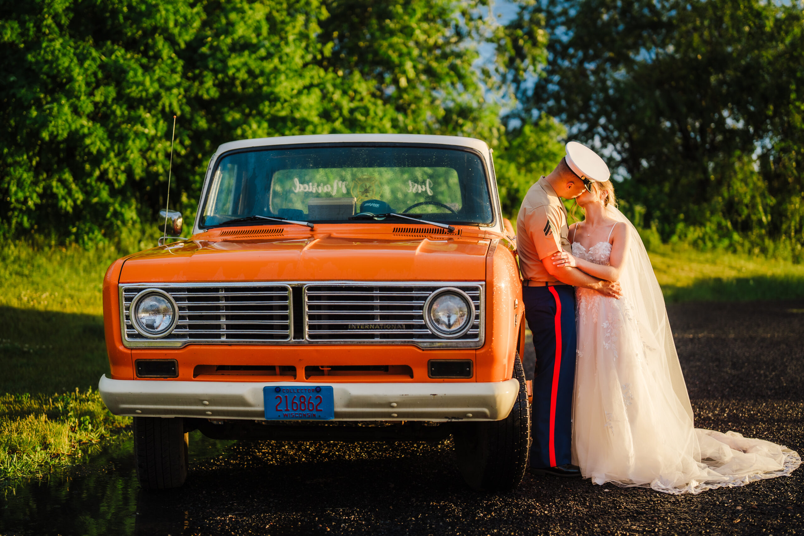 An army bride and groom pose next to an orange classic pickup truck after their Wisconsin wedding ceremony. Classic trucks Orange truck wedding Just married photo #weddinginspiration #weddingplanning #diywedding #wisconsinweddingphotographer #armywedding