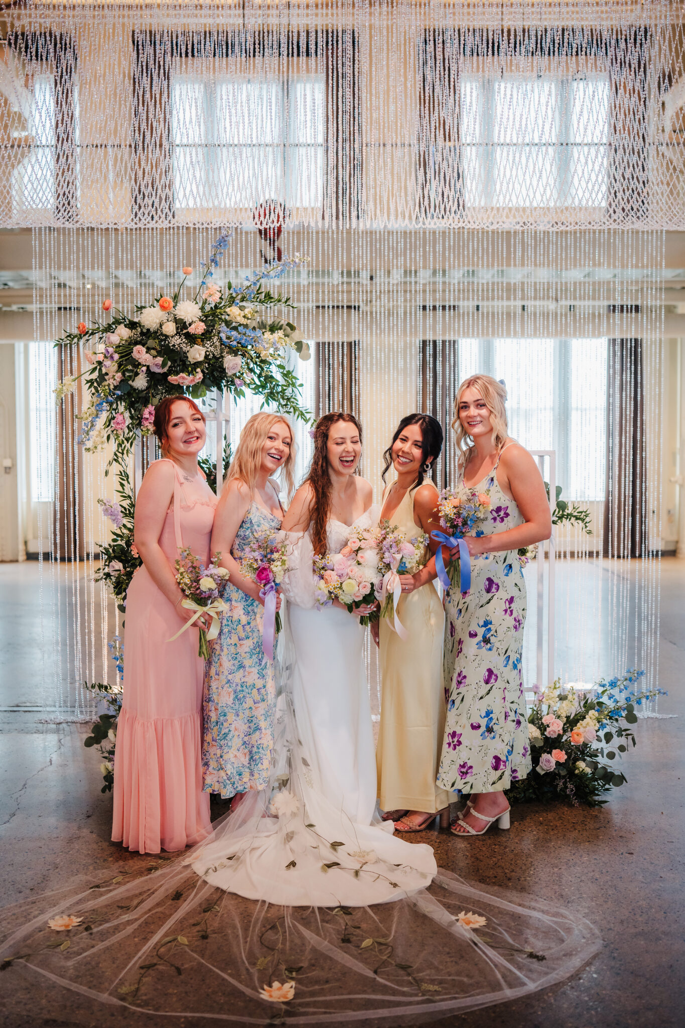 A bride stands at the altar with her bridesmaids in the elegant setting of The Machine Shop wedding venue, showcasing a moment of friendship, love, and anticipation in a stylish urban backdrop.