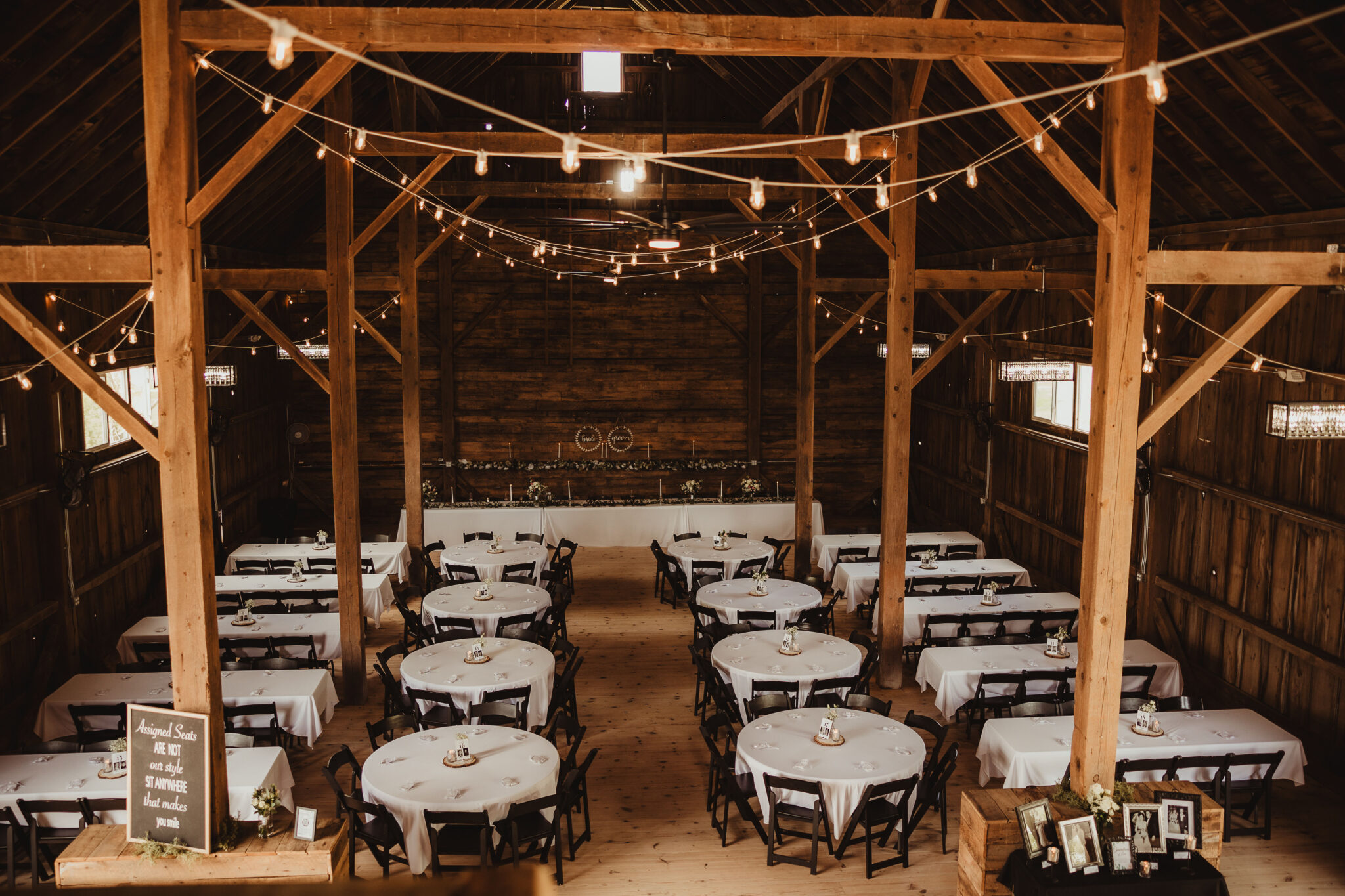 A rustic barn interior viewed from a balcony, adorned with charming hanging lights.