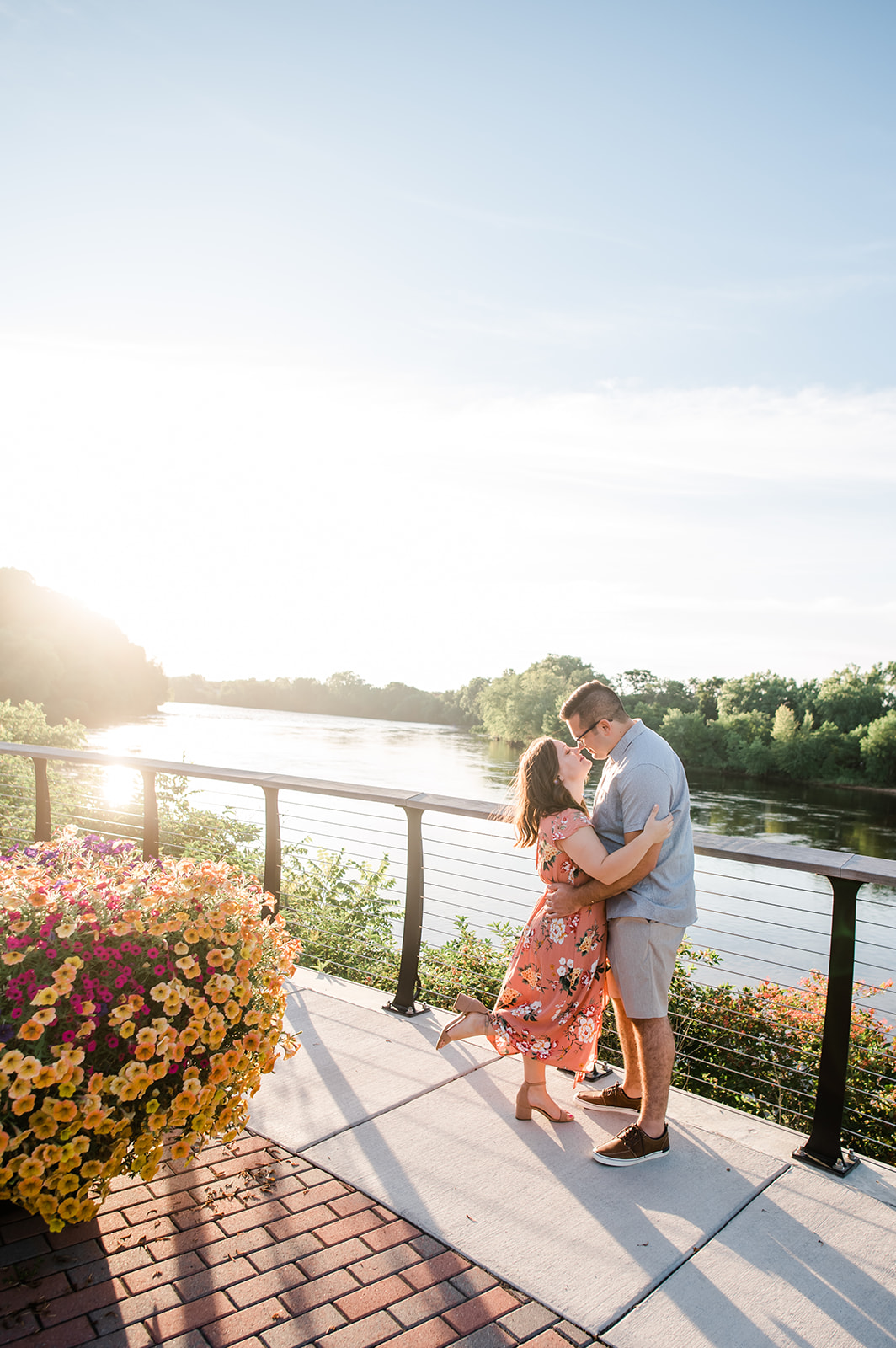 A couple stands on a balcony looking at eachother as the sun sets at Phoenix Park in Eau Claire, WI.