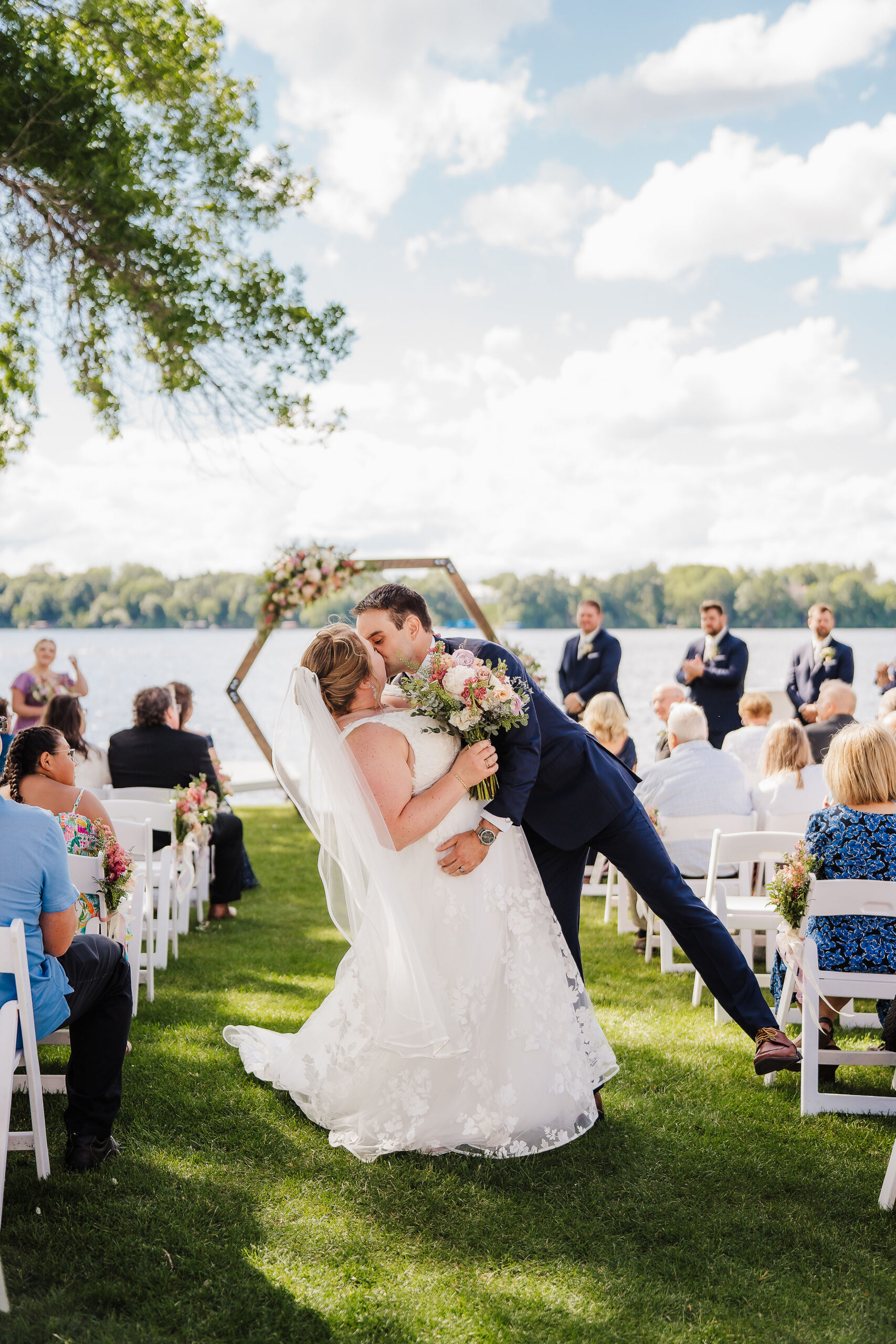 A couple walk hand in hand after being announced husband and wife on the shores of Lake Wissota Golf.